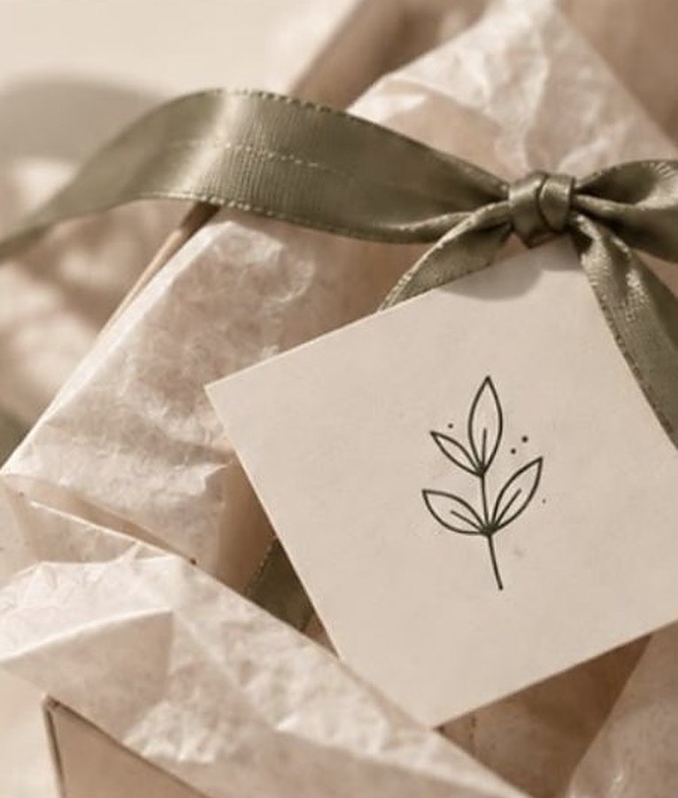 Box de regalo envuelto en papel de seda con cinta verde y tarjeta maia