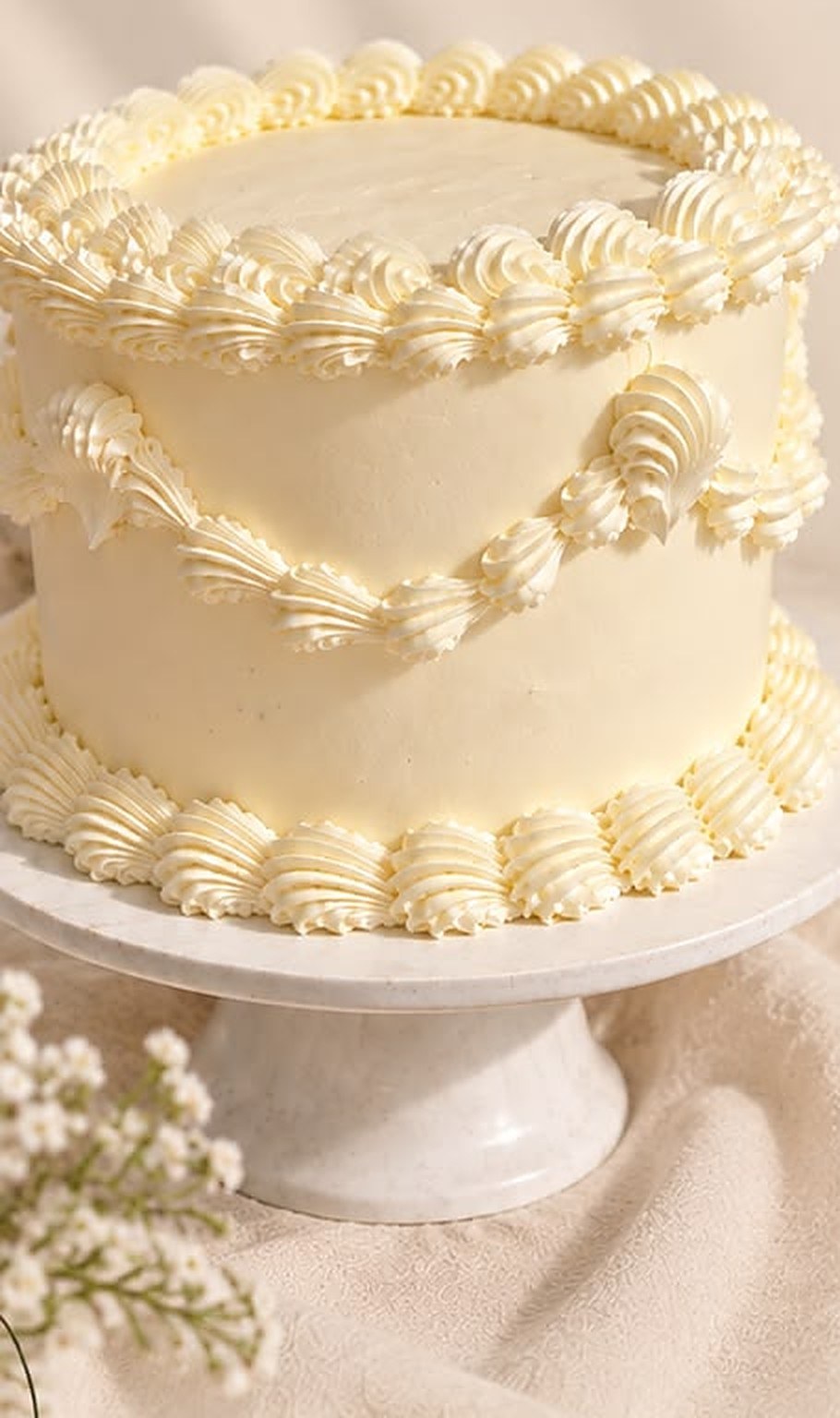 Torta color crema decorada con merengue y flores